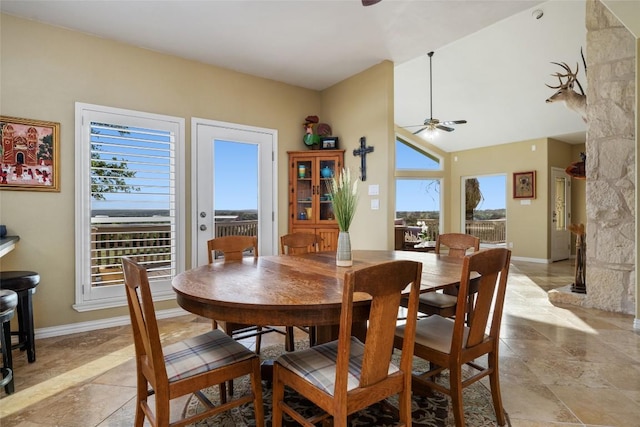 2400 W Fitzhugh Rd, Dripping Springs, TX 78630 - dining room with ceiling fan, baseboards, light stone finish flooring, and vaulted ceiling