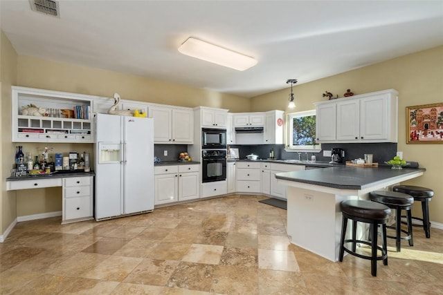 2400 W Fitzhugh Rd, Dripping Springs, TX 78630 - kitchen with black appliances, dark countertops, a peninsula, and under cabinet range hood