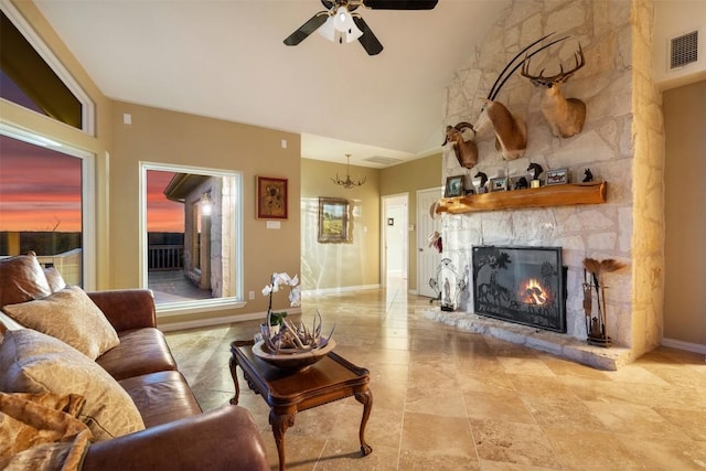 2400 W Fitzhugh Rd, Dripping Springs, TX 78630 - living room with a stone fireplace, a ceiling fan, baseboards, vaulted ceiling, and a chandelier