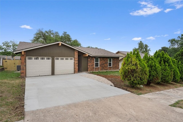 ranch-style house with fence, brick siding, driveway, a garage, and a shingled roof