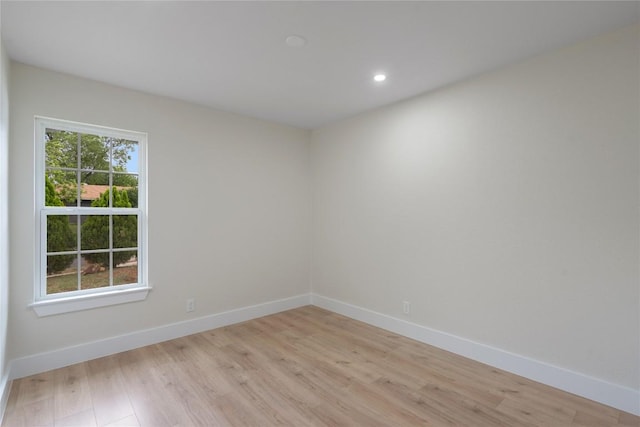 spare room with baseboards, recessed lighting, and light wood-type flooring