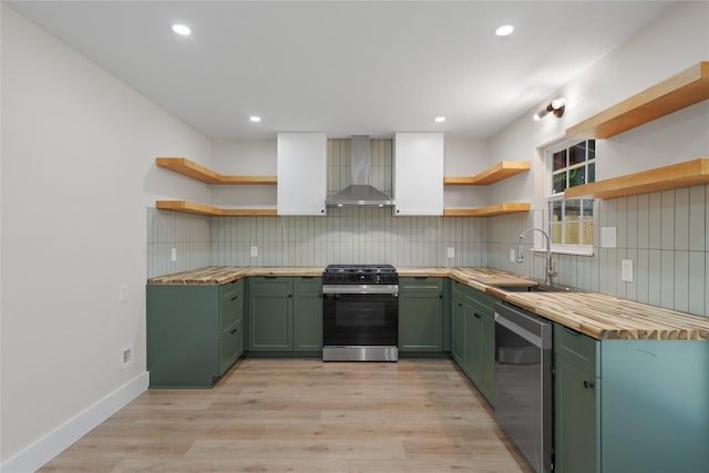 kitchen with wall chimney range hood, open shelves, and green cabinetry
