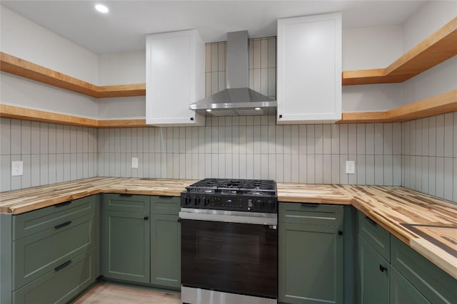 kitchen featuring green cabinets, wall chimney range hood, and butcher block counters