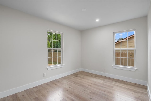 spare room featuring baseboards, light wood-style flooring, and recessed lighting