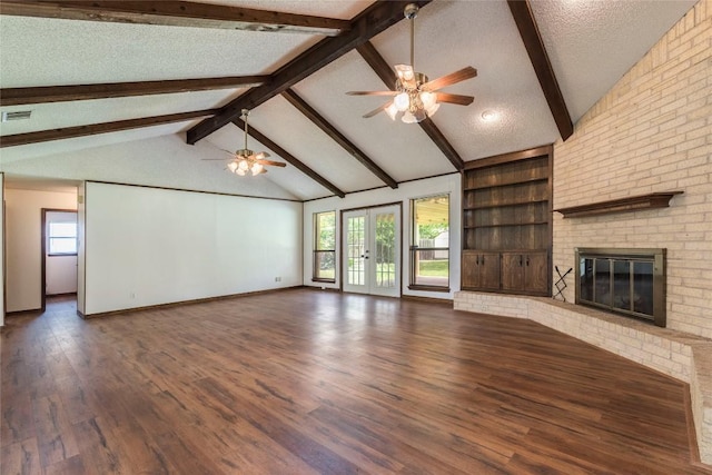 unfurnished living room with lofted ceiling with beams, wood finished floors, visible vents, a fireplace, and a ceiling fan