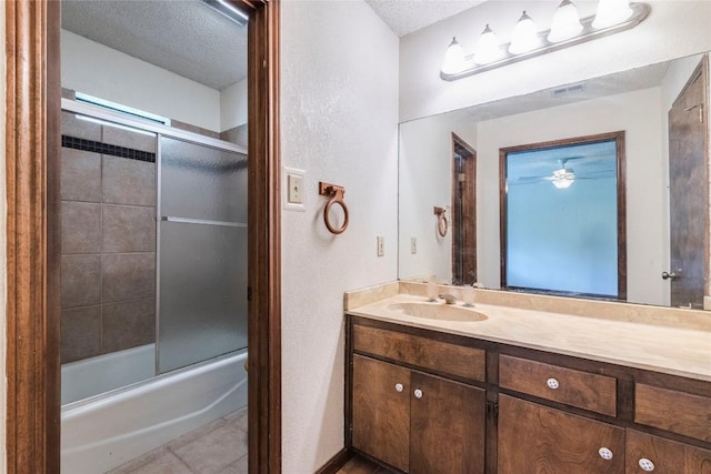 13505 Broadmeade Ave, Austin, TX 78729 - full bath with vanity, a textured ceiling, combined bath / shower with glass door, a ceiling fan, and tile patterned floors
