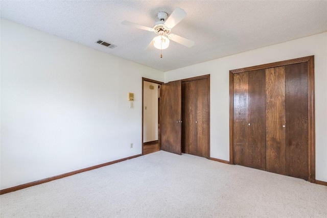 13505 Broadmeade Ave, Austin, TX 78729 - unfurnished bedroom with multiple closets, carpet, ceiling fan, and a textured ceiling