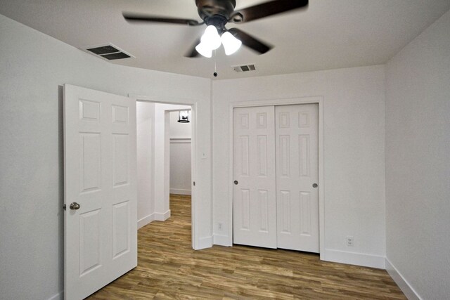 2539 Fayette Dr, New Braunfels, TX 78130 - unfurnished bedroom with wood finished floors, baseboards, a closet, and ceiling fan