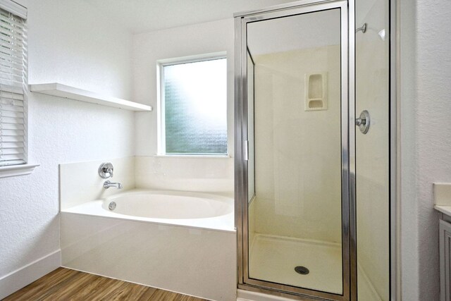 2539 Fayette Dr, New Braunfels, TX 78130 - full bathroom featuring wood finished floors, a stall shower, a garden tub, vanity, and a textured wall