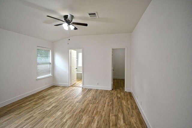 2539 Fayette Dr, New Braunfels, TX 78130 - unfurnished bedroom with lofted ceiling, wood finished floors, baseboards, ceiling fan, and ensuite bathroom