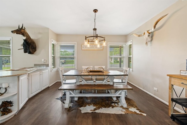 dining space with a wealth of natural light, a notable chandelier, and dark wood-type flooring