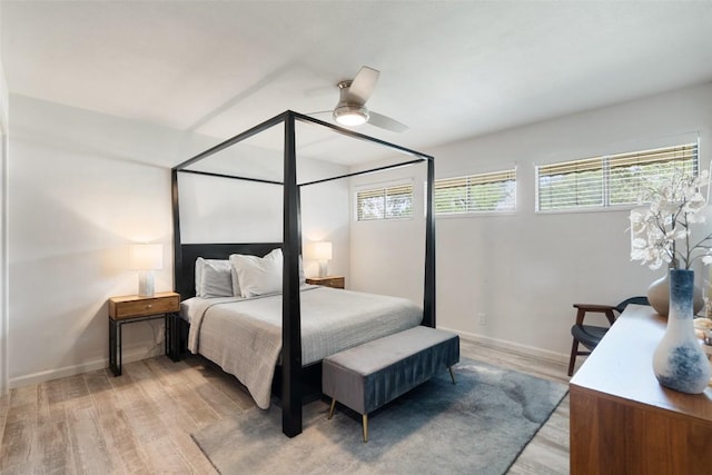 113 Comet, Lakeway, TX 78734 - bedroom featuring multiple windows, baseboards, light wood-style flooring, and a ceiling fan