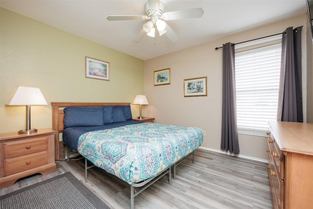 bedroom with baseboards, light wood-type flooring, and a ceiling fan