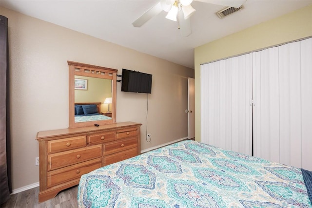 bedroom featuring visible vents, wood finished floors, baseboards, and ceiling fan