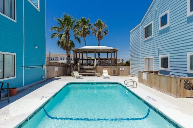 community pool featuring outdoor dry bar, fence, a gazebo, and a patio area