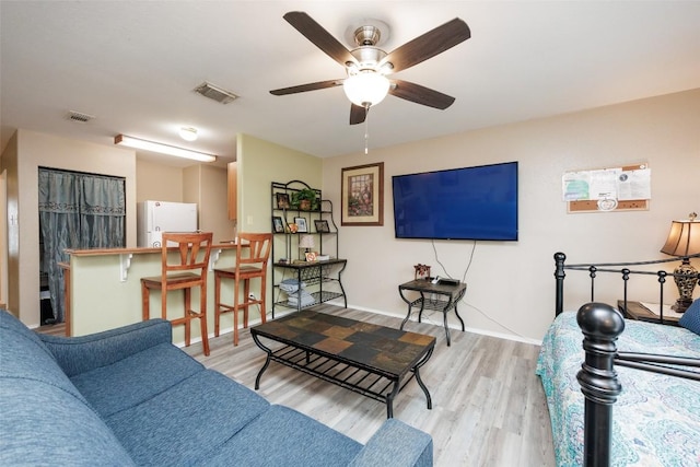 living area featuring visible vents, wood finished floors, and a ceiling fan
