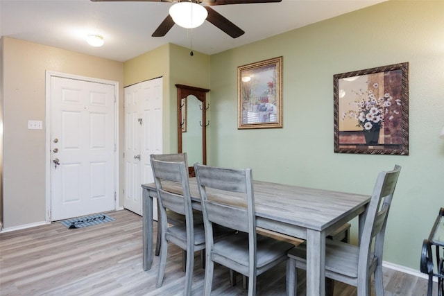 dining room with baseboards, light wood finished floors, and ceiling fan