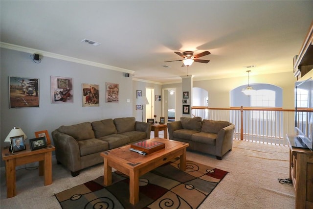 living room featuring ornamental molding, visible vents, ceiling fan, light carpet, and arched walkways