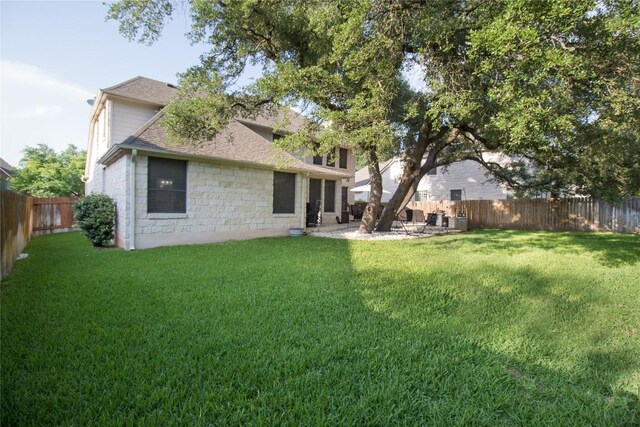 2005 Forest Hill Cv, Round Rock, TX 78665 - back of property with stone siding, roof with shingles, a fenced backyard, and a patio area
