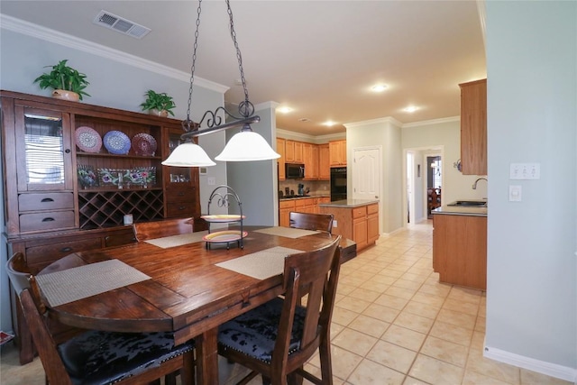 dining space with crown molding, visible vents, baseboards, and light tile patterned flooring