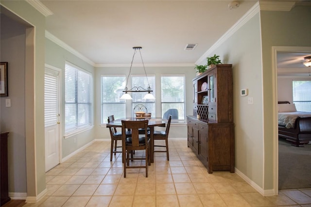 dining area with crown molding, a wealth of natural light, light tile patterned floors, and visible vents