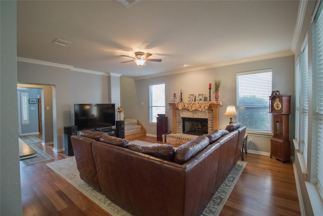 living room with wood finished floors, visible vents, a fireplace, and baseboards
