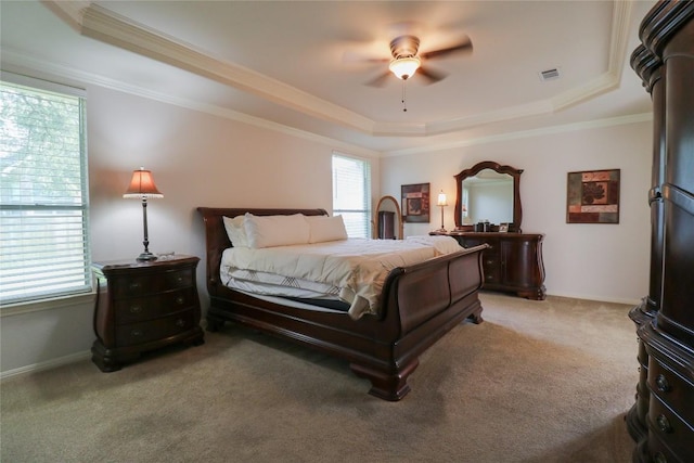 bedroom featuring ornamental molding, visible vents, light carpet, a ceiling fan, and a tray ceiling