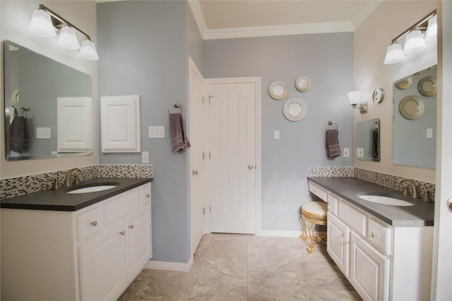 bathroom with crown molding, baseboards, and a sink