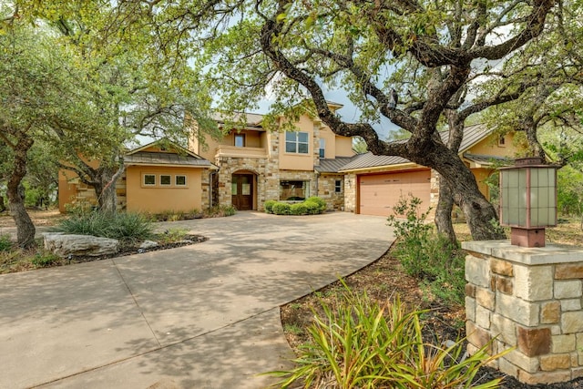 600 Mountain Dew Rd, Horseshoe Bay, TX 78657 - view of front facade with stone siding, concrete driveway, stucco siding, metal roof, and a standing seam roof