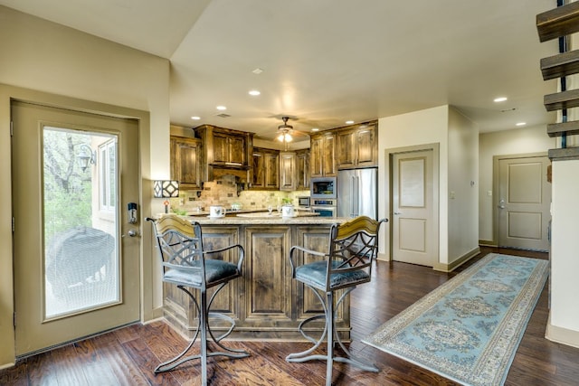 600 Mountain Dew Rd, Horseshoe Bay, TX 78657 - kitchen featuring baseboards, a breakfast bar, a peninsula, decorative backsplash, and appliances with stainless steel finishes
