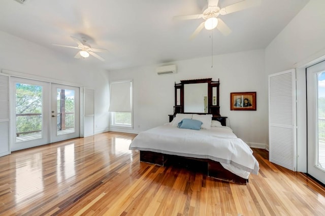 3701 Fischer Store Rd, Wimberley, TX 78676 - bedroom with light wood-style flooring, an AC wall unit, multiple windows, and access to exterior