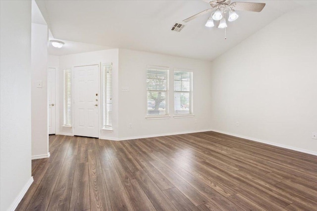 interior space with visible vents, baseboards, dark wood-type flooring, ceiling fan, and vaulted ceiling