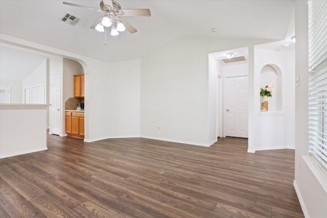 spare room featuring vaulted ceiling, ceiling fan, dark wood-style floors, and visible vents