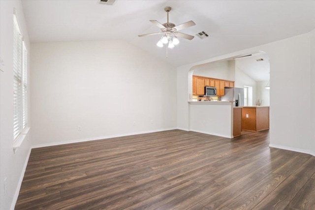 unfurnished living room with lofted ceiling, a ceiling fan, plenty of natural light, visible vents, and dark wood-style floors