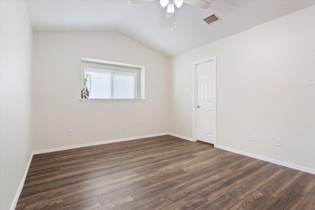 empty room with vaulted ceiling, visible vents, a ceiling fan, and dark wood-type flooring