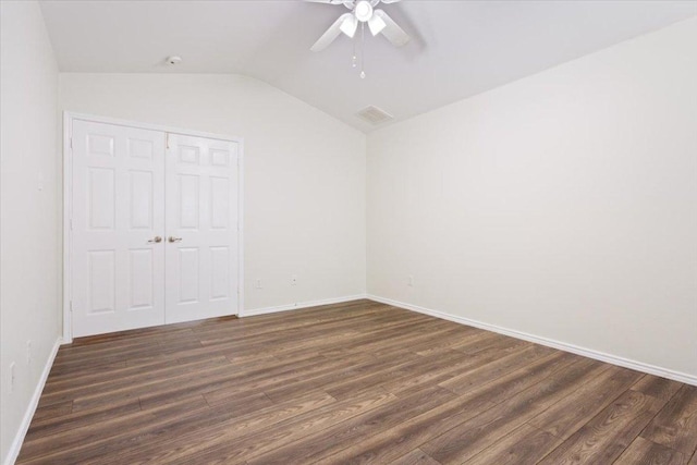 unfurnished bedroom with vaulted ceiling, a closet, visible vents, and dark wood finished floors