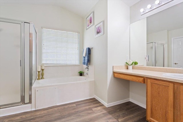 bathroom with lofted ceiling, wood finished floors, vanity, a shower stall, and a bath