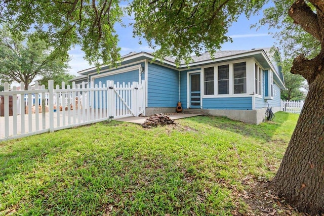 ranch-style house with a gate, a garage, a fenced backyard, a front lawn, and a sunroom