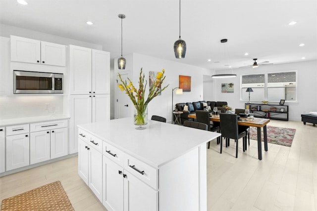 1500 Sylvan Glade Rd Unit 1A, Austin, TX 78745 - kitchen featuring stainless steel microwave, open floor plan, ceiling fan, recessed lighting, and white cabinets