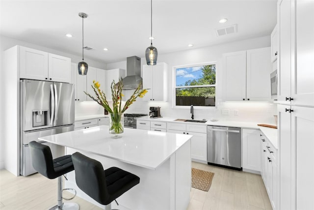 1500 Sylvan Glade Rd Unit 1A, Austin, TX 78745 - kitchen with appliances with stainless steel finishes, wall chimney exhaust hood, backsplash, a breakfast bar area, and light countertops