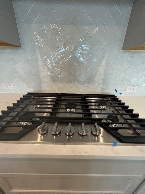 565 Raleigh Dr, Georgetown, TX 78633 - kitchen view of backsplash, stainless steel gas stovetop, and light stone countertops