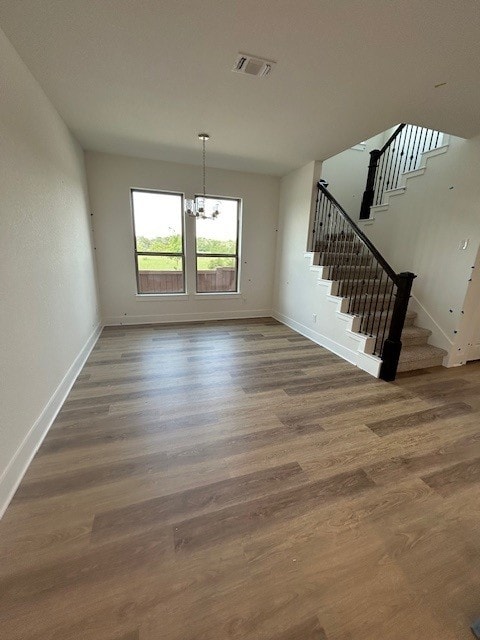 565 Raleigh Dr, Georgetown, TX 78633 - unfurnished dining area featuring stairway, baseboards, wood finished floors, and a chandelier