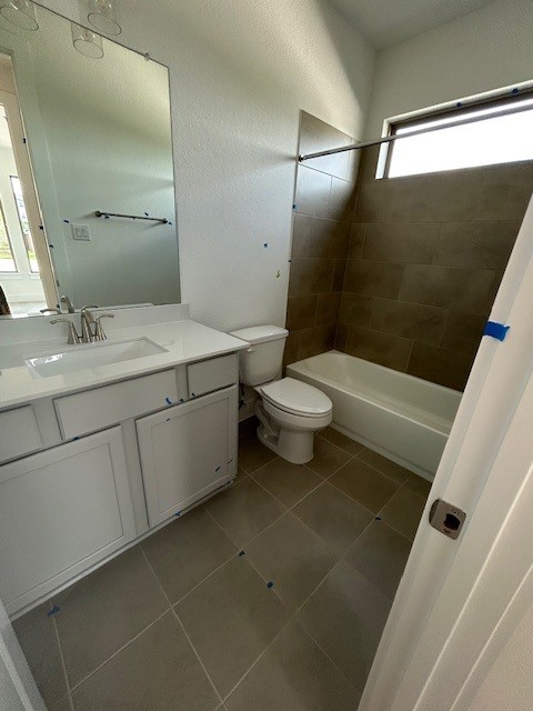 565 Raleigh Dr, Georgetown, TX 78633 - bathroom featuring tile patterned floors, toilet, vanity, and  shower combination