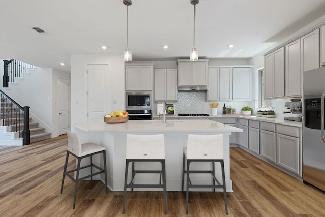 565 Raleigh Dr, Georgetown, TX 78633 - kitchen featuring gray cabinetry, stainless steel appliances, light wood-type flooring, light countertops, and recessed lighting