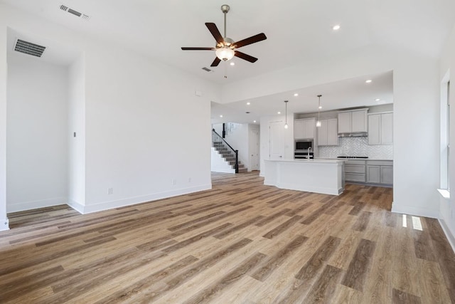 565 Raleigh Dr, Georgetown, TX 78633 - unfurnished living room with a ceiling fan, light wood finished floors, recessed lighting, and stairway