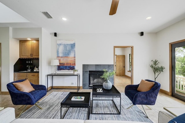living room featuring visible vents, recessed lighting, a ceiling fan, baseboards, and a tile fireplace