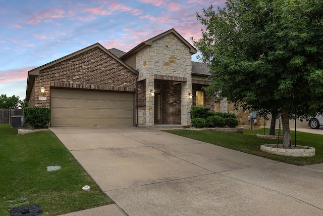 french country inspired facade featuring stone siding, a garage, concrete driveway, a front yard, and brick siding