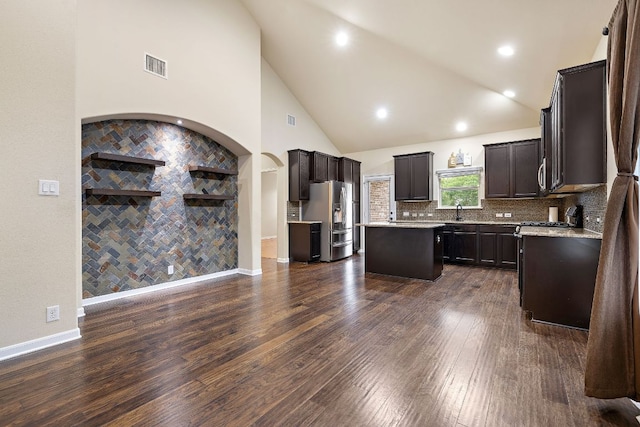 kitchen with light countertops, stainless steel fridge with ice dispenser, a center island, and visible vents