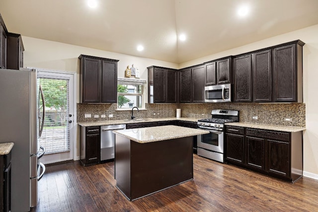 kitchen featuring a sink, stainless steel appliances, dark brown cabinetry, backsplash, and dark wood-style floors