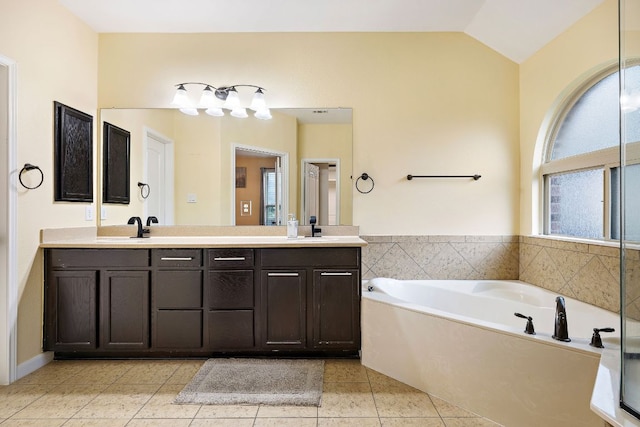 full bath with double vanity, a sink, tile patterned floors, a bath, and lofted ceiling